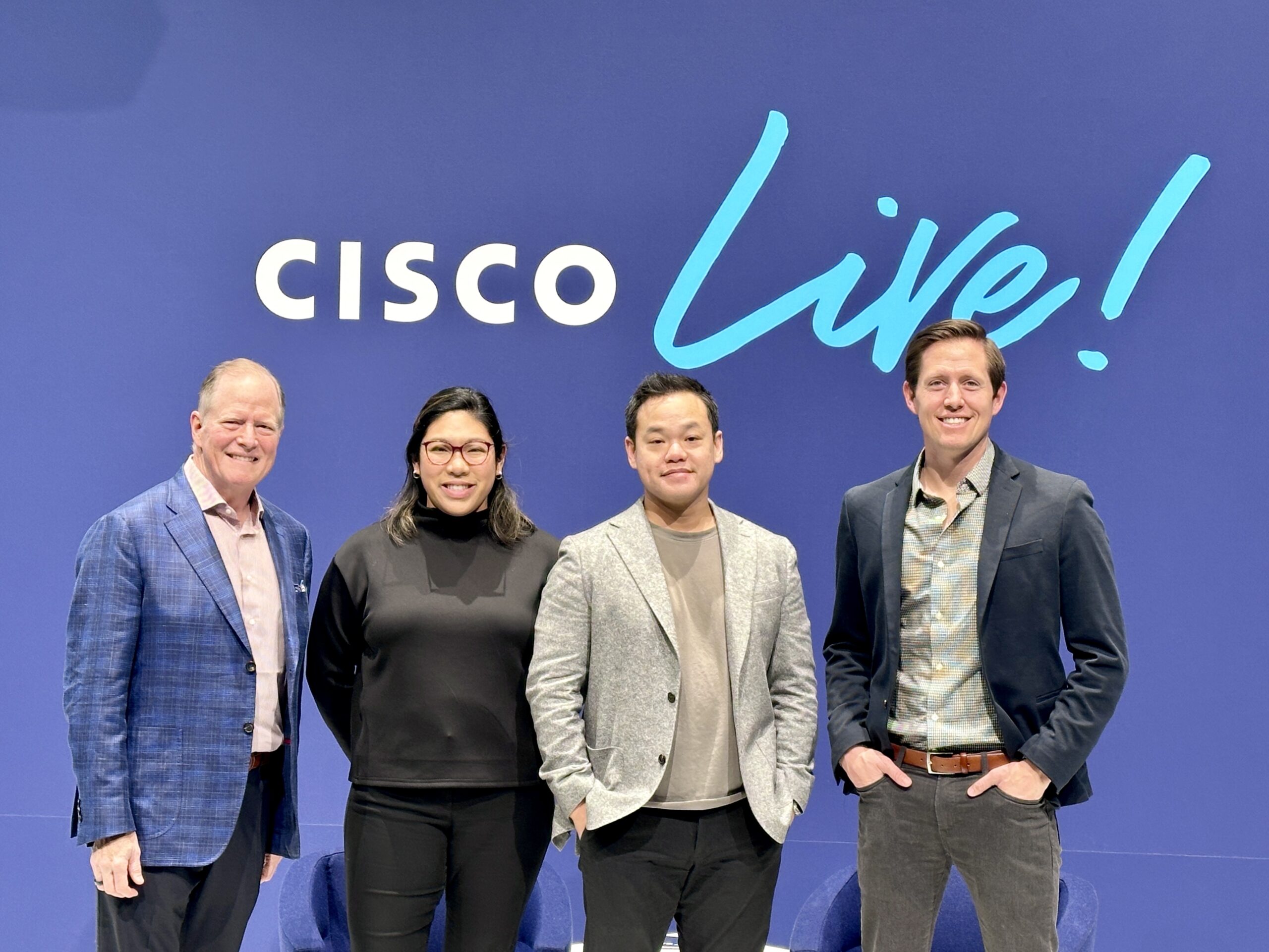 Journey team in front of Cisco Live sign
