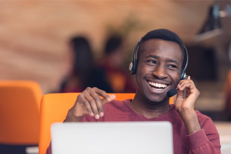 Smiling contact center agent with laptop