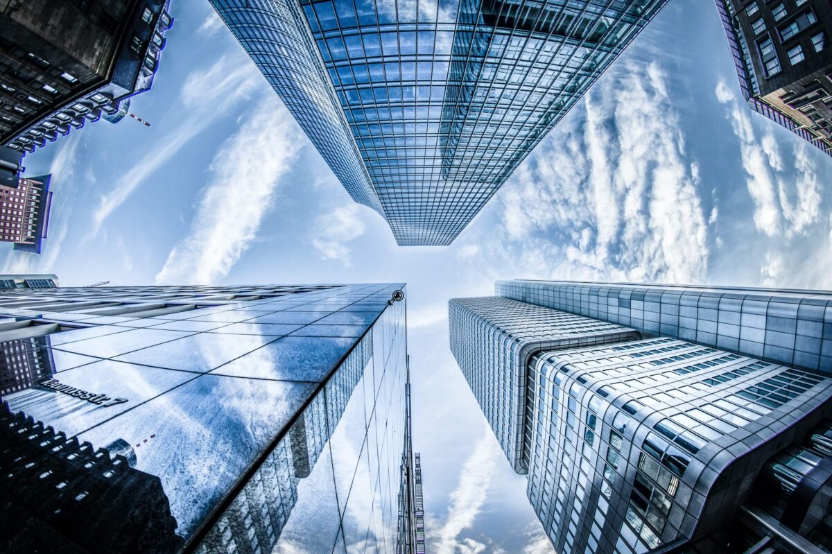 Looking up at tall buildings with a blue sky