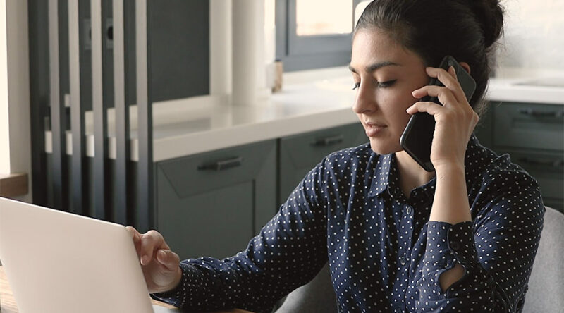 Woman using computer and phone