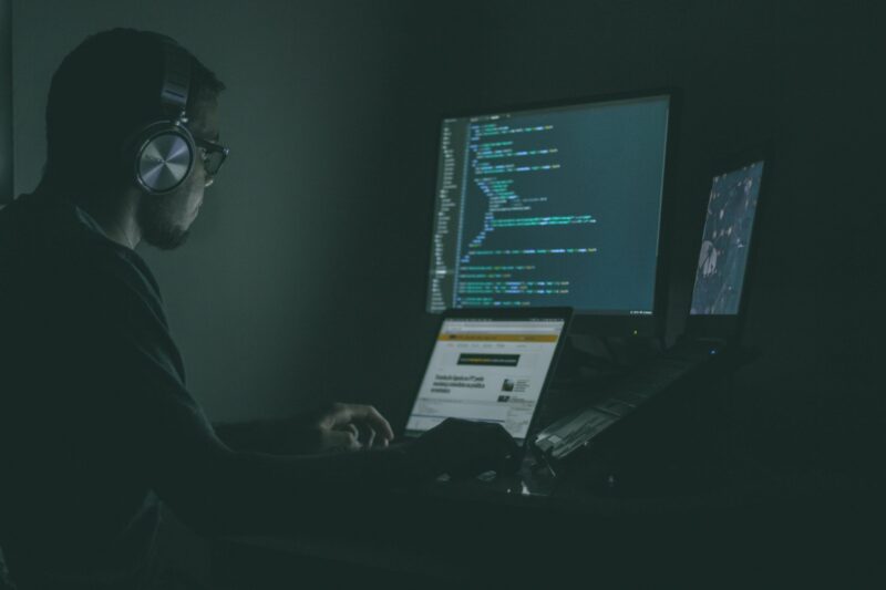 Person coding in dark room